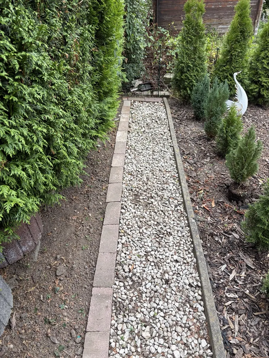Vom Bewuchs befreiter Kiesweg nach der Gartenpflege